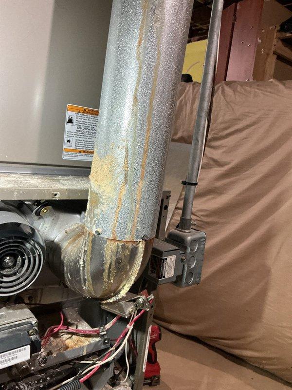 Performed diagnostic on 12-year-old non-operational furnace located in basement. Inspection revealed significant corrosion on ductwork connections and elbow joints with visible rust streaks indicating possible condensation issues. Identified damaged components in the motor/fan assembly that required replacement to restore proper functionality.