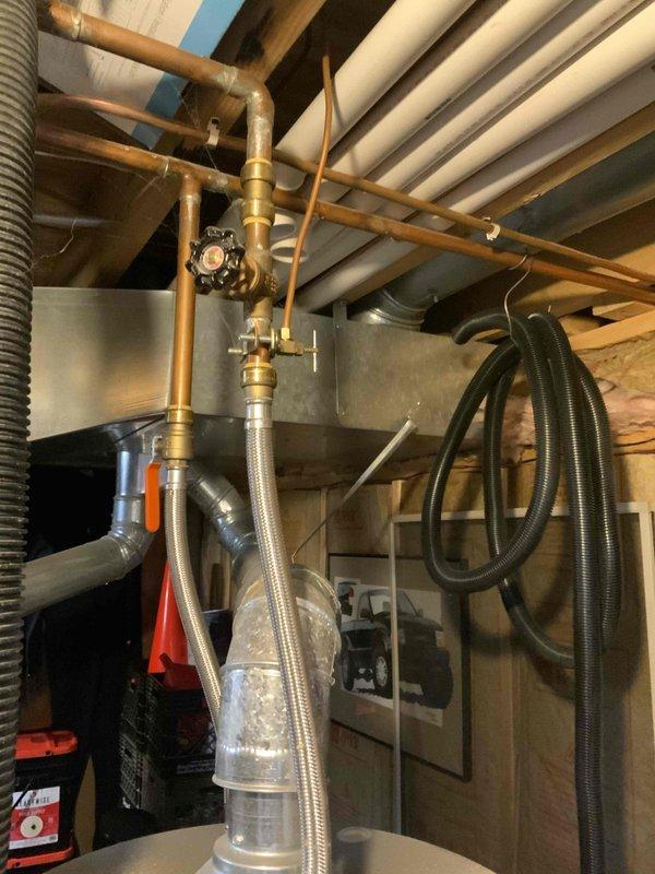 Conducted evaluation of 26-year-old functional furnace and A/C system located in basement. Inspection revealed aging copper piping infrastructure with brass valve assembly and associated ductwork. Recommended replacement of existing HVAC system with new equipment to improve efficiency and reliability before end of service life.