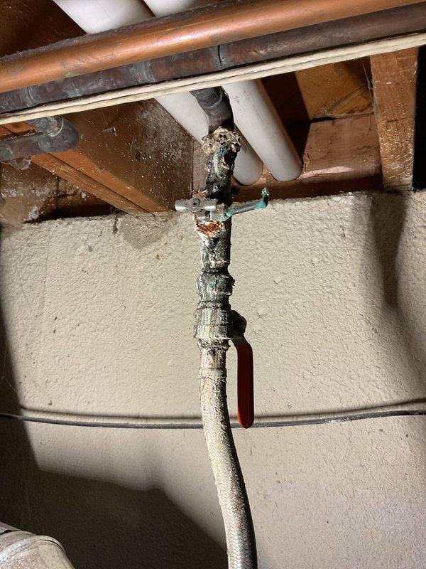 Completed scheduled Air Care Heating and Cooling maintenance service. Identified significant corrosion and mineral deposits at pipe connection points near water heater, with visible leakage evidence at copper/metal pipe junctions. Documented severe oxidation and deterioration of plumbing components that will require follow-up repair to prevent further water damage.