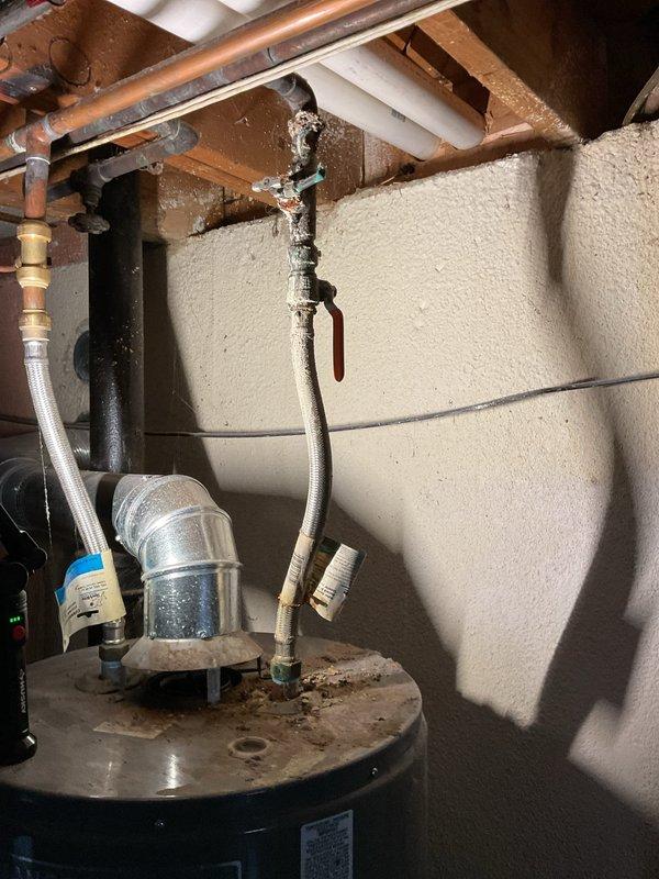 Completed scheduled Air Care Heating and Cooling maintenance service. Identified significant corrosion and mineral deposits at pipe connection points near water heater, with visible leakage evidence at copper/metal pipe junctions. Documented severe oxidation and deterioration of plumbing components that will require follow-up repair to prevent further water damage.