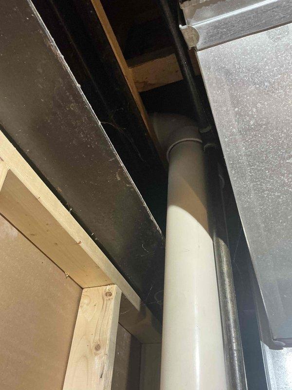 Conducted inspection of a 2003 basement HVAC system with compromised heat exchanger that is barely operational. Documented existing installation including PVC venting configuration and interior furnace compartment with visible copper refrigerant lines. Provided replacement estimate for furnace and A/C system to address end-of-life equipment concerns.