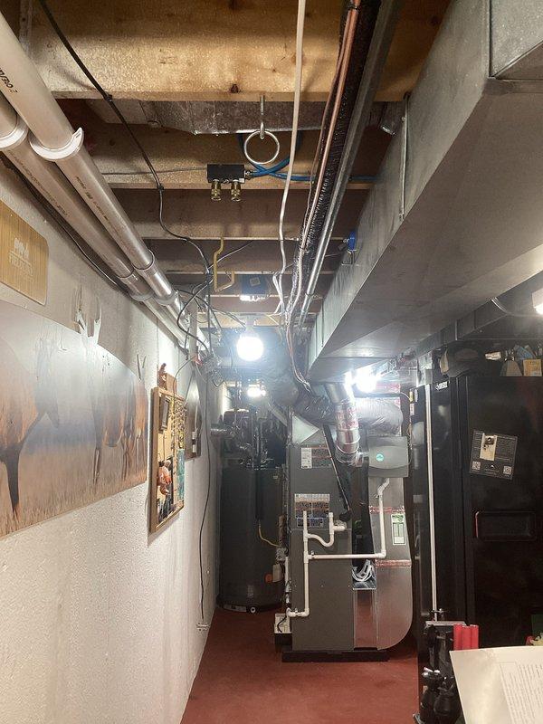 Successfully completed installation of complete HVAC system including a 70,000 BTU furnace, 3-ton AC unit, and humidifier in residential basement utility area. System required mechanical and electrical permits, with all ductwork properly connected and PVC venting installed according to code requirements.