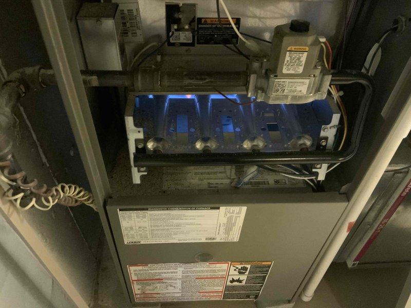 Conducted an estimate for replacement of a 20-year-old furnace and A/C system located in the basement. Visual inspection revealed an operational gas burner assembly with proper blue flame pattern indicating complete combustion, though the age of the equipment warrants replacement. Noted water damage and possible mold in adjacent utility area that may require remediation during installation of new system.