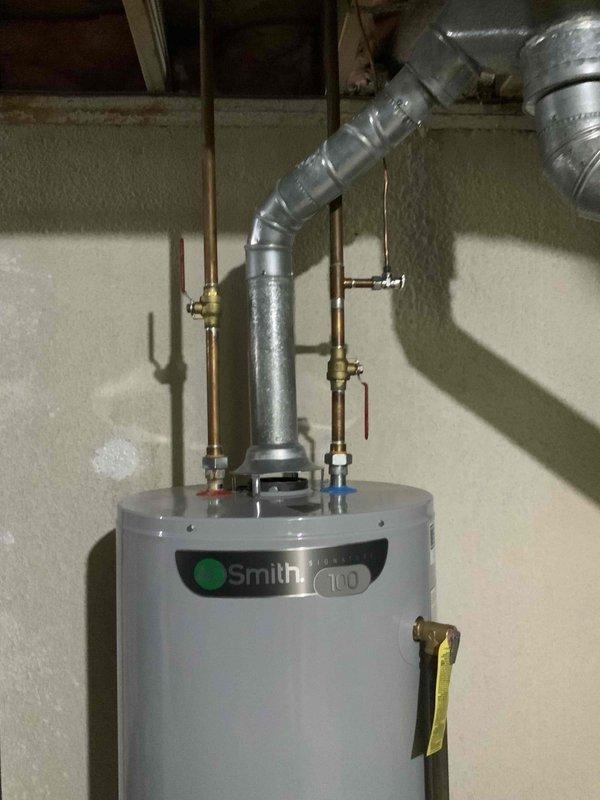 Conducted full system evaluation of 33-year-old forced air natural gas system in ranch home with basement installation. Inspected electrical panel for proper amperage capacity and documented existing water heater specifications (Smith 100) with current venting configuration. System replacement estimate provided for furnace and A/C components.