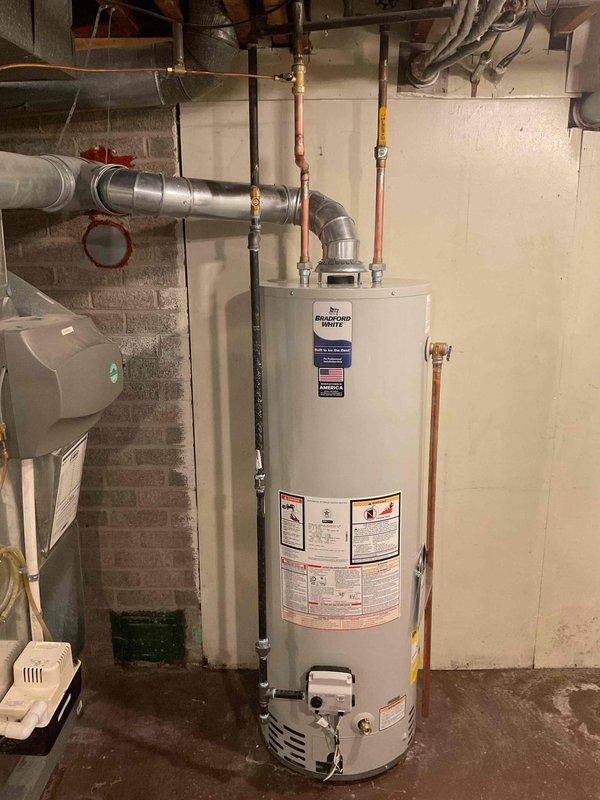 Successfully installed a 40-gallon Bradford White tanked water heater in basement utility room. Completed all necessary plumbing connections including copper supply lines and proper metal venting ductwork. Mechanical and hot water heater permits were requested and reconnection was completed according to code requirements.