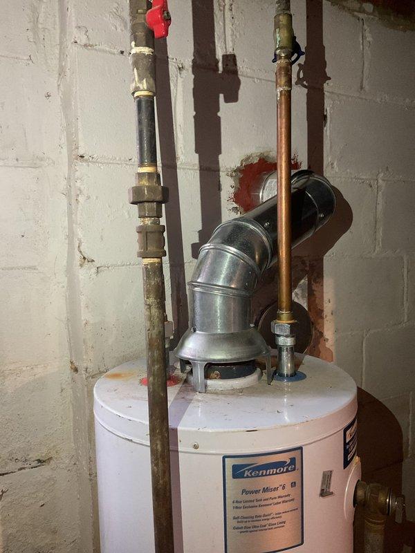 Returned to complete installation by dropping chimney liner and installed magnet strip for air filter as required. Verified proper connection of metal ductwork to wall penetration and confirmed water heater vent pipe system was correctly installed with appropriate clearances.