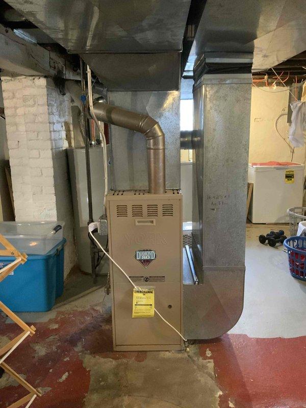 Conducted comprehensive assessment for new AC installation in residential property with no existing cooling system. Inspected current heating infrastructure, which includes a functional furnace with connected ductwork in the basement utility area. Documented water heater location and existing ventilation to evaluate complete HVAC integration requirements for proposed cooling system.