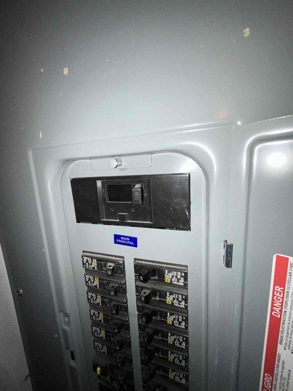 Completed electrical estimate for a new Generac whole home generator installation. Inspected the existing electrical panel in an unfinished basement area, which features a digital power monitoring display and dual columns of circuit breakers. Documentation of the current electrical setup was captured to inform proper generator sizing and connection requirements.