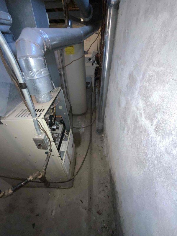 Completed inspection of a 15-year-old non-operational furnace located in the basement. Documented existing HVAC system configuration including ductwork, ventilation piping, and connections to water heater. Provided replacement estimate for new furnace under current BOGO air conditioning promotion.