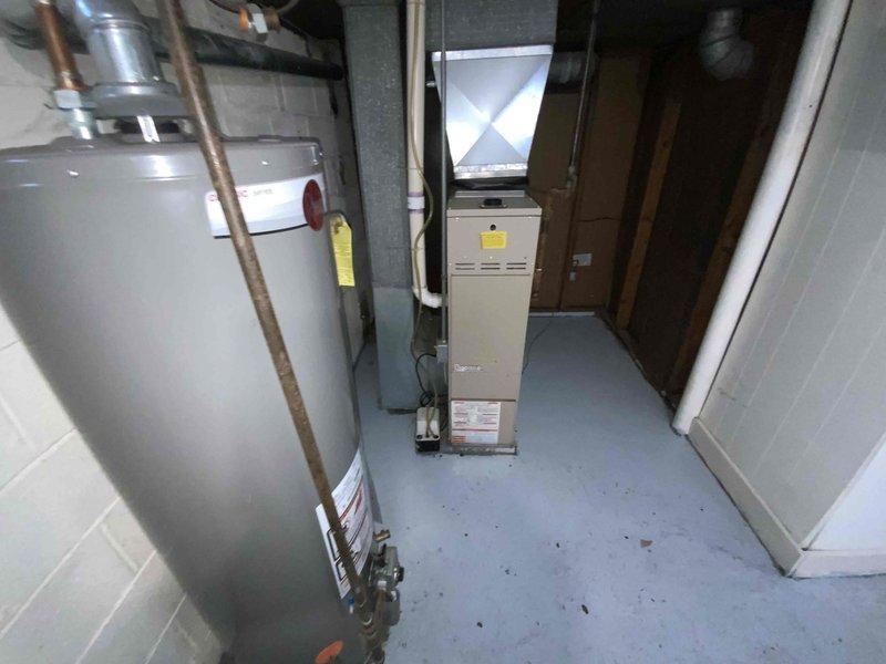 Conducted an estimate for replacement of a non-operational 35+ year old furnace located in the basement. Documented existing HVAC setup including the furnace unit with connected ductwork and nearby water heater installation. Evaluation confirms replacement is necessary due to equipment age and failure.