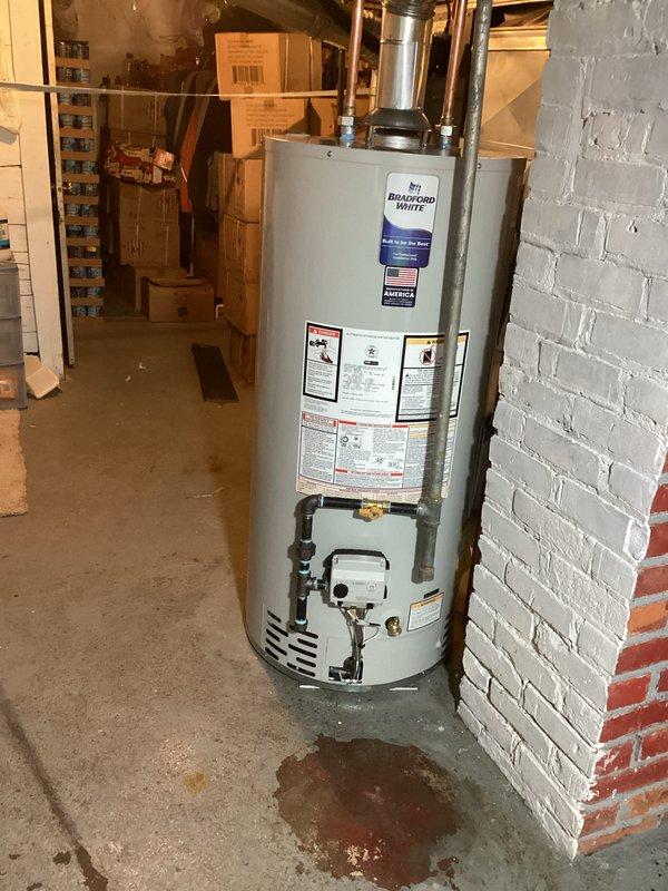 Successfully installed a Bradford White 40-gallon tanked water heater in basement utility area, including proper connection of copper supply lines and drain piping. All mechanical permits were secured in advance and installation was completed according to code requirements with no rebates applicable.