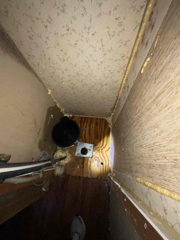 Conducted inspection of mobile home water heater installation site where customer had already removed the existing unit. Observed exposed wall cavity with visible plumbing connections including an insulated pipe. Noted electrical junction box present in the confined space. Site requires standard (non-tankless) water heater replacement suitable for mobile home application.