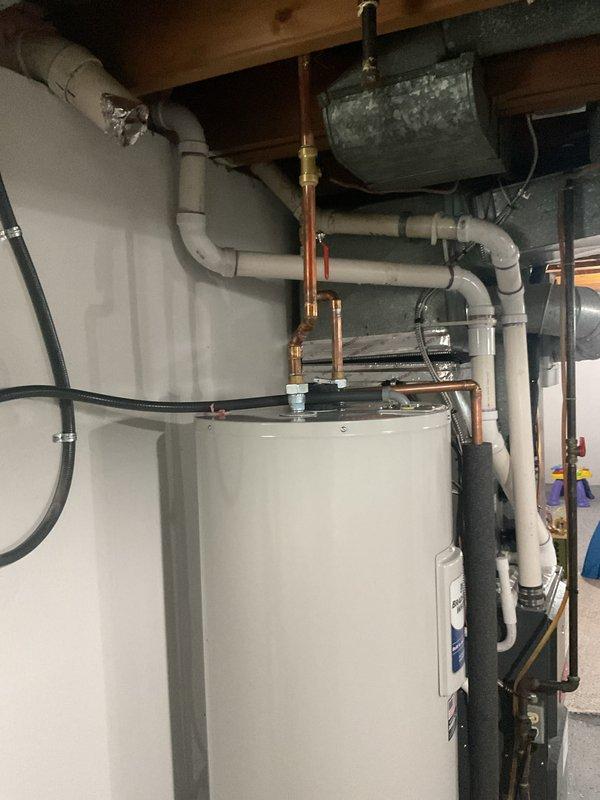 Successfully installed and activated a new electric hot water heater with appropriate electrical connections. Completed all necessary plumbing work including copper pipe connections with brass fittings and PVC pipe integration. Verified proper operation of the unit with all safety mechanisms functioning correctly.