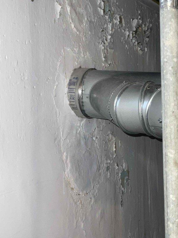 Conducted assessment of 30-year-old basement furnace for potential replacement. Observed significant wall deterioration with peeling paint around ductwork, suggesting possible moisture issues. System includes older galvanized ductwork connected to the furnace unit, with nearby water heater ("Defender" model) sharing the utility space.