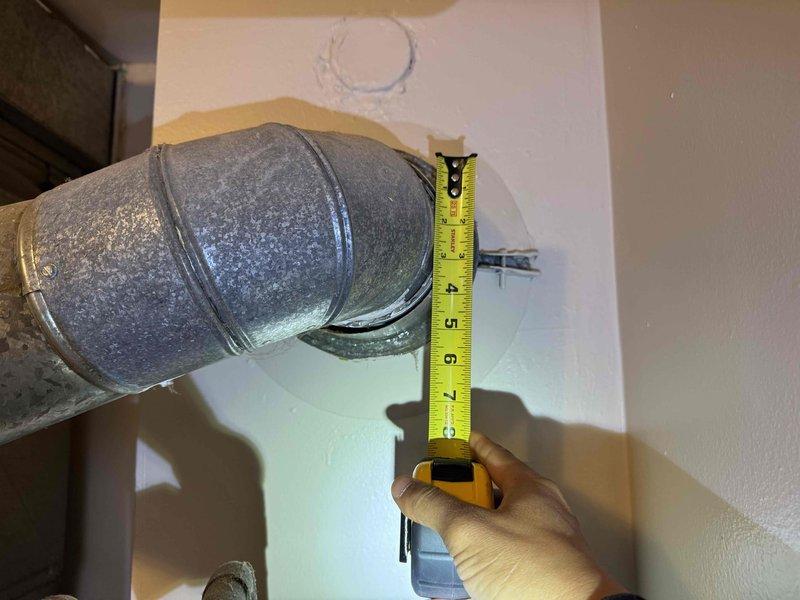 Completed measurements of existing ductwork and access panel for a small-to-mid sized heating and cooling system installation. Verified 7-inch galvanized metal duct pipe joint dimensions and documented access panel measurements in preparation for natural gas/propane HVAC system to be installed in closet location.