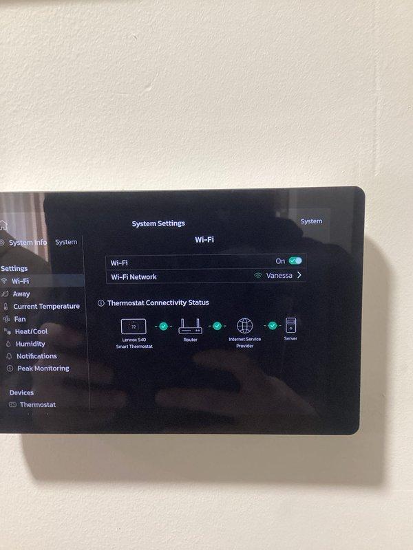 Diagnosed and resolved WiFi connectivity issue on 1-year-old Lennox S40 Smart Thermostat. Confirmed thermostat is now properly connected to home network "Vanessa" with full connectivity to router, ISP and server. System operating normally with heat function maintaining 74°F indoor temperature against 29°F outdoor temperature.