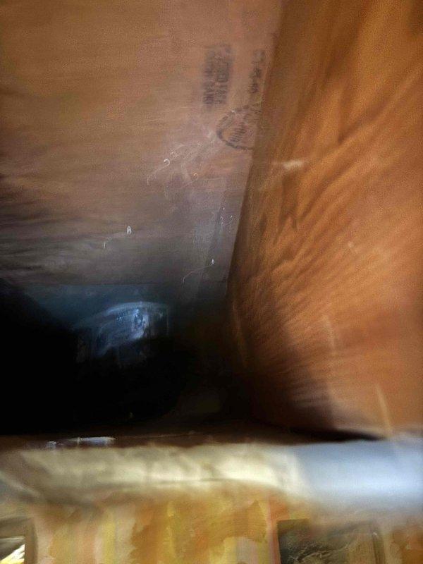 Conducted assessment of 20+ year old natural gas furnace located in basement for potential replacement. Performed visual inspection of installation area, noting unfinished plumbing space with exposed wooden joists and existing PVC drainage. Identified suitable pathway for new line set installation through existing joist structure to accommodate furnace and AC system replacement.