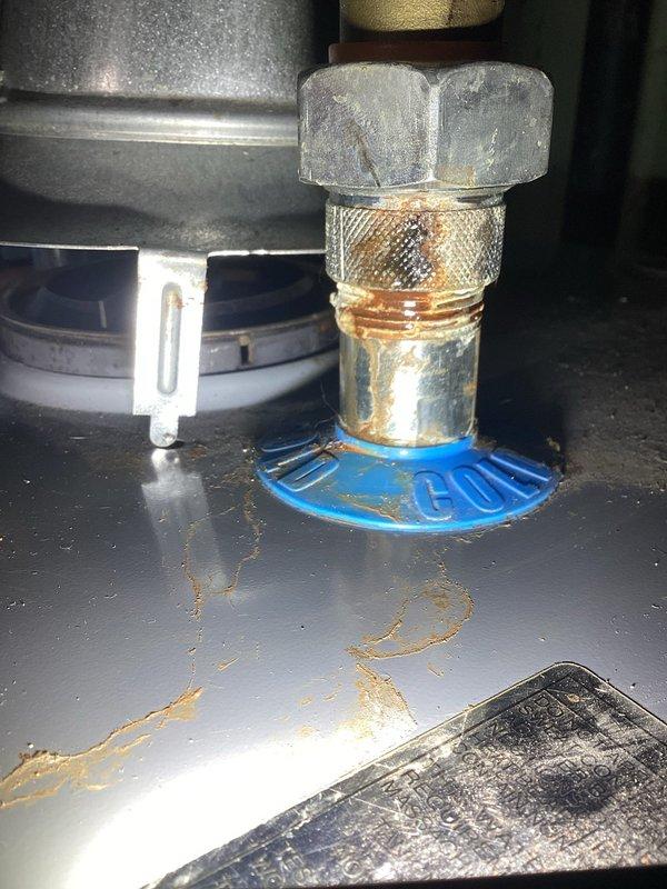 Diagnosed and repaired leaking connection point on 50+ year old tanked water heater system. Identified significant corrosion and mineral buildup at copper pipe junction, with visible oxidation staining on surrounding components. Serviced deteriorated fittings and inspected exhaust ventilation to ensure proper functionality and prevent future leakage issues.