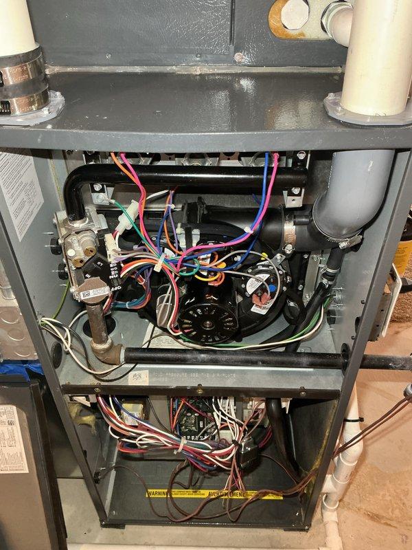 Performed annual heating maintenance service on HVAC system. Inspected interior components including blower motor, electrical connections, and control boards. Noted some moisture/condensation on upper metal tray surface that will require monitoring. Customer advised that replacement filters are needed.