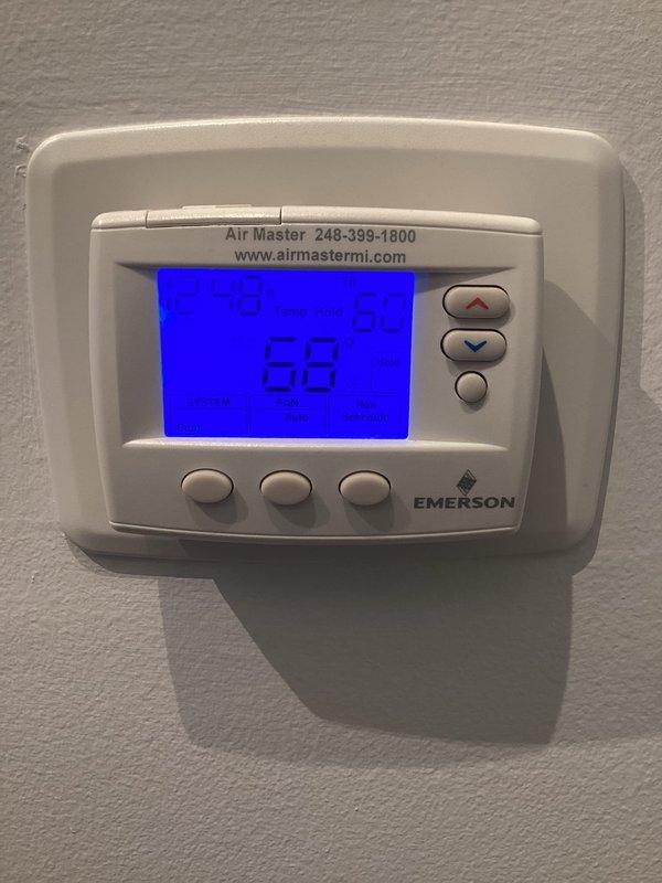 Performed scheduled maintenance on Emerson thermostat and outdoor AC condenser unit. System was inspected for proper operation with thermostat reading 68°F and functioning correctly. Exterior condenser unit was examined, showing no visible damage or unusual wear, with proper installation on concrete pad and adequate drainage bed.