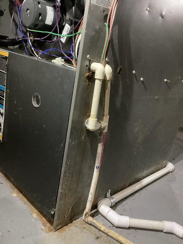 Responded to no-heat complaint on 12-year-old forced air furnace system. Diagnostic inspection revealed faulty electrical components with corrosion at condensate drain connection point. Replaced damaged wiring harness and motor components, cleaned corroded connections, and verified proper system operation before completing service.