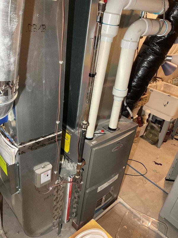 Conducted assessment of non-operational water heater replacement needs. Inspected existing HVAC system configuration, including furnace unit with PVC ventilation pipes, associated ductwork, and plumbing connections. Customer unavailable until 4:15; determination of vent type (power vent vs. natural draft) pending further inspection.