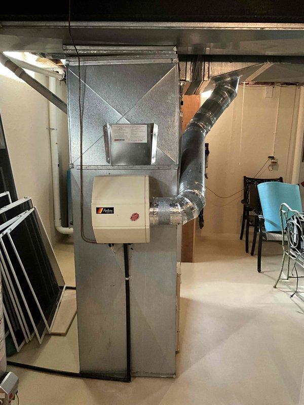 Performed estimate for replacement of 32-year-old gas furnace system showing signs of leakage. Current installation includes aging Falco-branded furnace with Y-shaped ductwork configuration and connected humidifier, all located in basement. Unit is operational but requires replacement due to age and water leakage issues.