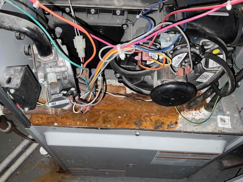 Conducted full system estimate on 18-year-old GMC HVAC unit for customer requiring immediate replacement. Inspection revealed significant interior corrosion and rust on the furnace base panel, indicating potential moisture damage or age deterioration. Visual assessment included documentation of electrical connections and utility placement for proper system sizing and installation planning.