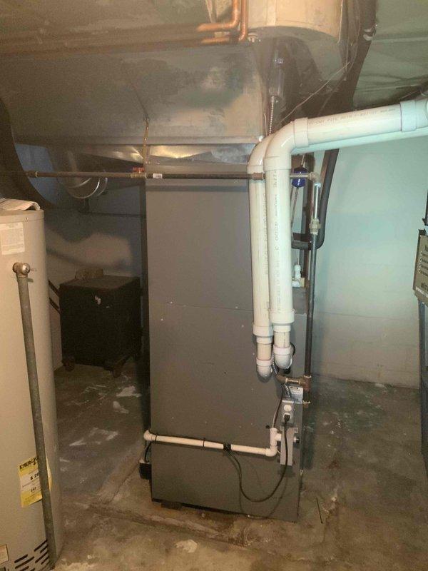 Performed comprehensive evaluation of 17-year-old furnace and hot water tank located in customer's basement. Unit is currently operational but approaching end of service life. Documented existing installation including PVC ventilation system, ductwork connections, and utility pipe configurations to prepare accurate replacement estimate.