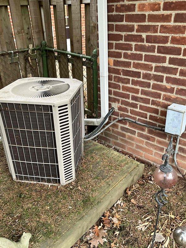 Conducted comprehensive evaluation of 16-year-old AC and heating system for potential replacement. Inspected outdoor condenser unit mounted on concrete pad with associated electrical connections and refrigerant lines. Examined indoor ductwork configuration and copper line set routing in utility access area. Documented system condition and installation constraints to prepare detailed replacement estimate as requested by customer.