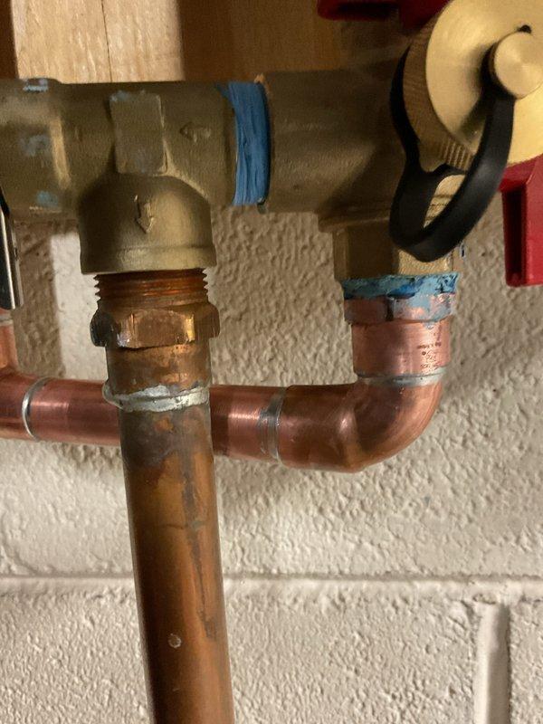 Responded to callback for recently installed tankless water heater exhibiting a small drip from one of the connections. Inspected copper pipe assembly and brass valve connections, identified leak source at soldered joint. Repaired defective connection and verified system integrity with no further leakage observed.