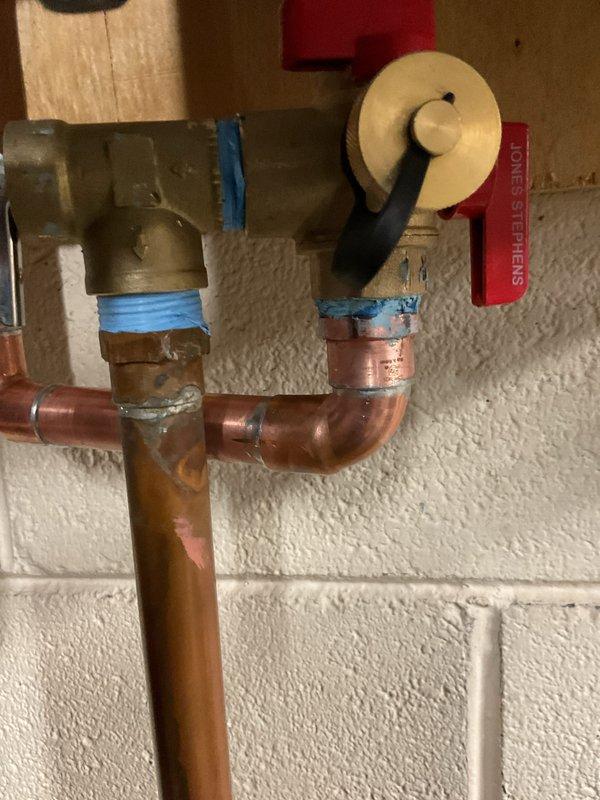 Responded to callback for recently installed tankless water heater exhibiting a small drip from one of the connections. Inspected copper pipe assembly and brass valve connections, identified leak source at soldered joint. Repaired defective connection and verified system integrity with no further leakage observed.