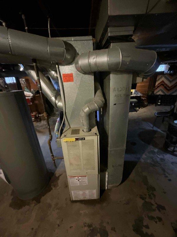 Conducted HVAC system replacement quote in basement utility area. Existing unit shows signs of age with visible duct deterioration and possible moisture issues as evidenced by floor staining. Quoted BOGO promotion for complete system replacement including furnace and associated ductwork modifications.