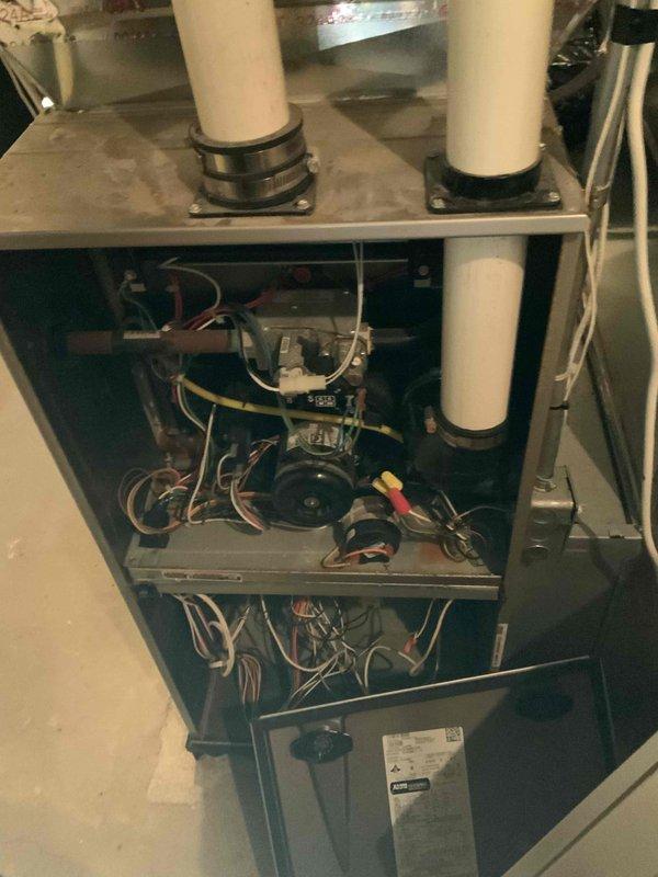 Inspected 6-year-old natural gas furnace system in basement. Unit is currently operational but showing signs of wear on blower motor assembly and electrical components. Examined PVC exhaust/intake piping configuration and condensate drainage system with integrated safety switch. Documented current condition for replacement quote consideration.