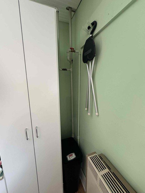 Conducted replacement estimate for 20-year-old direct vent wall furnace in residential property. Inspected existing unit mounted on mint green wall with yellow gas line connection, noting age-related wear. Documented current installation configuration for proper sizing of replacement equipment.
