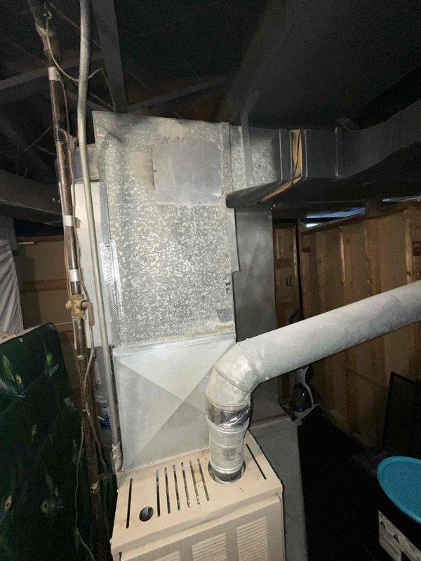 Performed assessment of non-functioning 30+ year old HVAC system in basement. Inspection revealed aging furnace with deteriorated ventilation components and outdated ductwork showing significant dust accumulation and wear. Recommended complete replacement of furnace and AC unit under current BOGO promotion to restore proper heating and cooling functionality.