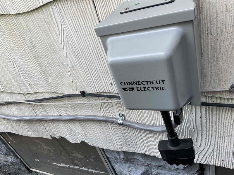 Conducted site assessment for new whole home generator installation. Inspected existing electrical system, documenting deteriorated wiring with visible insulation wear and disorganized cable management. Evaluated exterior Connecticut Electric service connection box mounted on siding for potential integration with generator system.