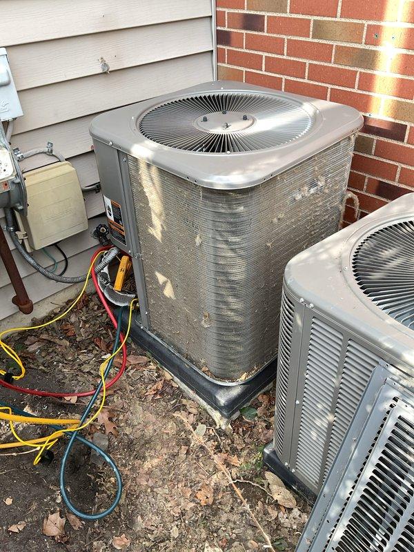 Performed annual maintenance on two outdoor AC condensing units. Inspected older unit showing significant dirt accumulation on coils and exterior casing with possible corrosion, while the newer unit was in better condition. Maintenance included checking service lines (yellow, red, blue) connected to electrical disconnect box, and noted replacement filters/pads are needed.