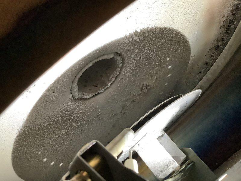 Responded to service call for 10-year-old leaking water heater. Diagnostic inspection revealed significant condensation on tank components and possible ventilation issues as evidenced by moisture accumulation around the ventilation cover. Recommended replacement due to age and extent of leakage, as unit is beyond manufacturer's warranty coverage.