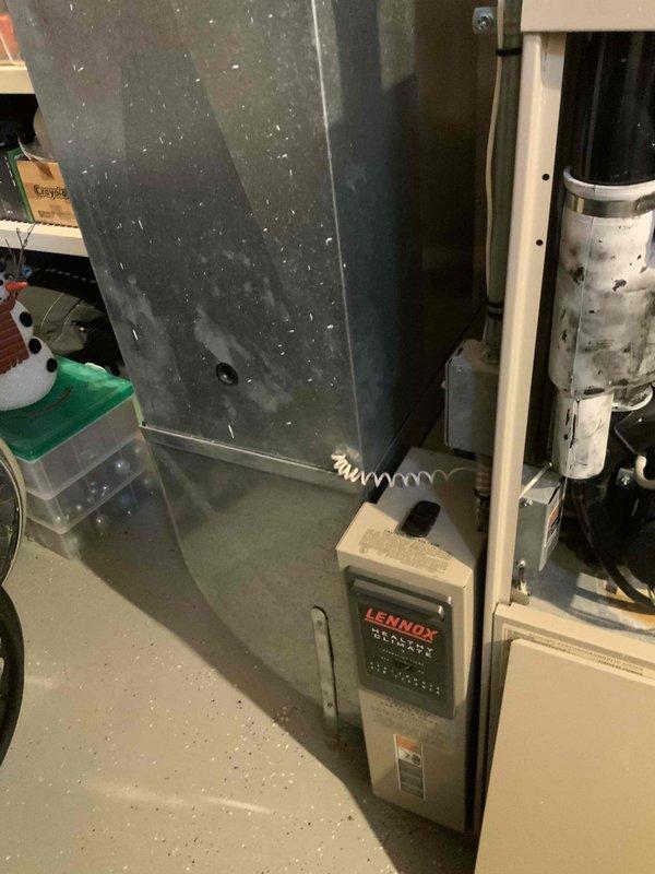 Completed assessment of 25-year-old Lennox furnace system and hot water tank replacement in basement. System currently operational but showing significant wear, dust accumulation, and age-related deterioration. Documented existing ductwork configuration and PVC venting for proper replacement planning.