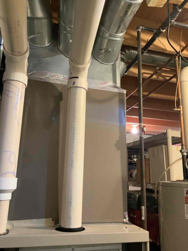 Completed assessment of 25-year-old Lennox furnace system and hot water tank replacement in basement. System currently operational but showing significant wear, dust accumulation, and age-related deterioration. Documented existing ductwork configuration and PVC venting for proper replacement planning.