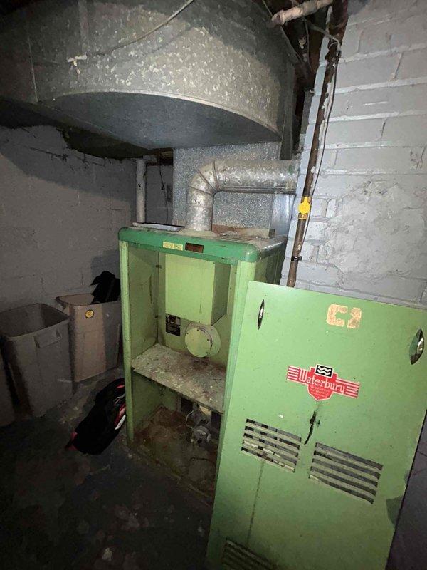 Performed detailed inspection of 40+ year old non-functional Waterbury natural gas furnace located in basement. Documented extensive age-related deterioration and wear on internal components. Evaluated electrical service panel and existing ductwork configuration for replacement compatibility. Recommended complete system replacement with new furnace and air conditioning unit per promotional bundle offering.