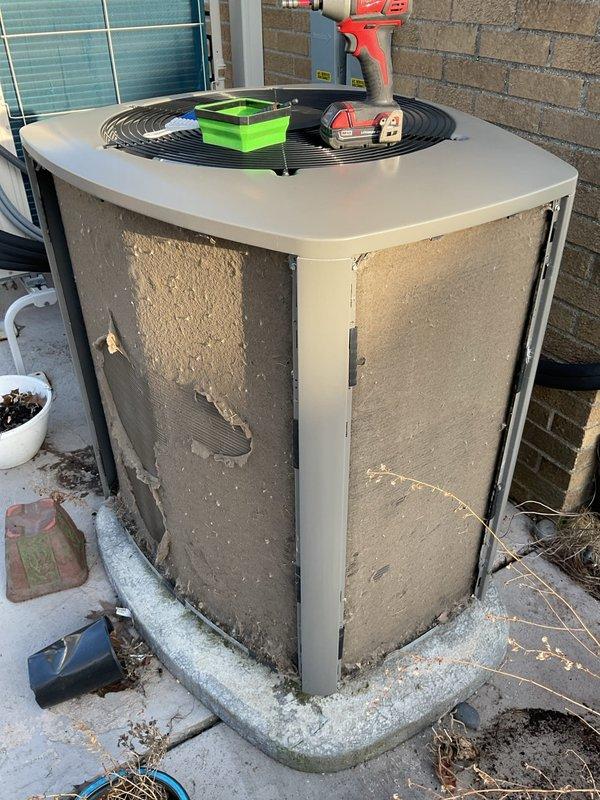 Performed ComfortGuard maintenance package service on HVAC system, which included inspection of outdoor condensing unit showing significant exterior deterioration and internal component exposure. Replaced spots filter and installed new air scrubber as requested, and conducted comprehensive system evaluation with documentation via photos of both outdoor unit and furnace interior components to verify operational status.