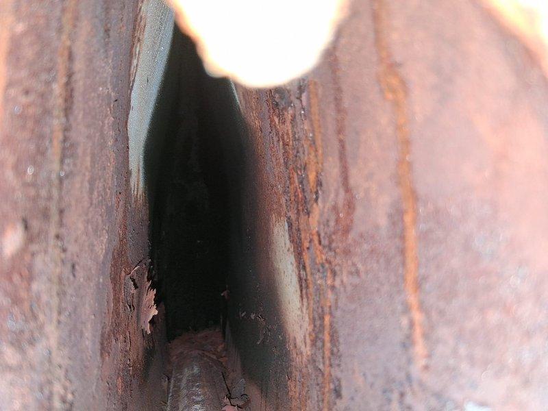 # HVAC Maintenance - AHM Service Report

Completed routine annual furnace maintenance as part of preventative maintenance membership program. Performed comprehensive tune-up on 0-year-old furnace system including standard inspection, cleaning, and operational testing protocols.

During visual inspection, identified severe rust and corrosion on heat exchanger components. Metal surfaces displayed extensive deterioration with reddish-brown oxidation and textured scaling throughout, indicating prolonged moisture exposure. U-shaped heat exchanger channels showed significant rust penetration with darker interior surfaces and compromised structural integrity. Sharp metal edges exhibited less corrosion but surrounding areas demonstrated pervasive deterioration requiring immediate attention.

Secondary inspection revealed additional corrosion evidence on furnace cabinet and internal mounting surfaces. Vertical rust streaking patterns observed on cabinet panels and wooden structural supports, co