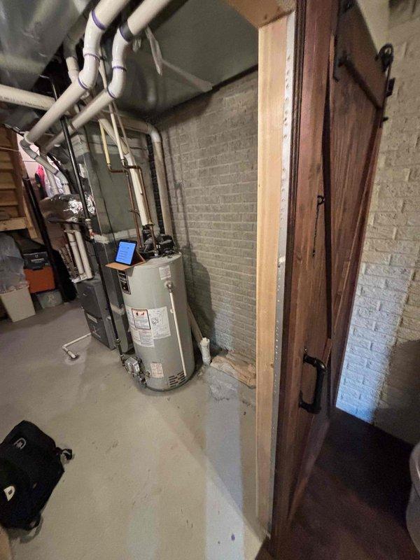 # Water Heater Replacement Estimate

Conducted on-site assessment for water heater replacement in residential basement mechanical room. Evaluated existing tan cylindrical water heater unit with overhead ductwork and plumbing connections, including supply and discharge piping configuration. Documented current installation conditions, noting exposed PVC plumbing infrastructure running through adjacent basement bathroom area. Photographed equipment specifications, mechanical room layout, and existing pipe routing to develop comprehensive replacement proposal. Provided detailed estimate for new water heater installation including necessary code-compliant modifications to venting, gas lines, and water connections.