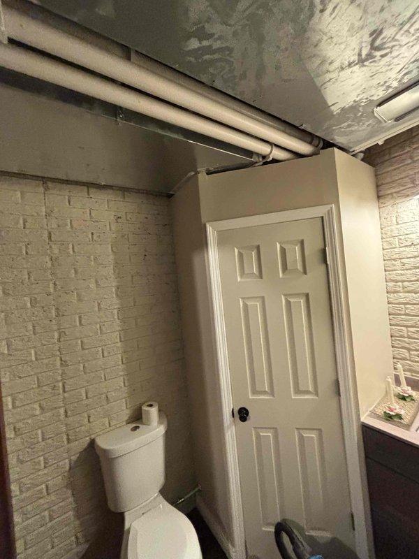 # Water Heater Replacement Estimate

Conducted on-site assessment for water heater replacement in residential basement mechanical room. Evaluated existing tan cylindrical water heater unit with overhead ductwork and plumbing connections, including supply and discharge piping configuration. Documented current installation conditions, noting exposed PVC plumbing infrastructure running through adjacent basement bathroom area. Photographed equipment specifications, mechanical room layout, and existing pipe routing to develop comprehensive replacement proposal. Provided detailed estimate for new water heater installation including necessary code-compliant modifications to venting, gas lines, and water connections.