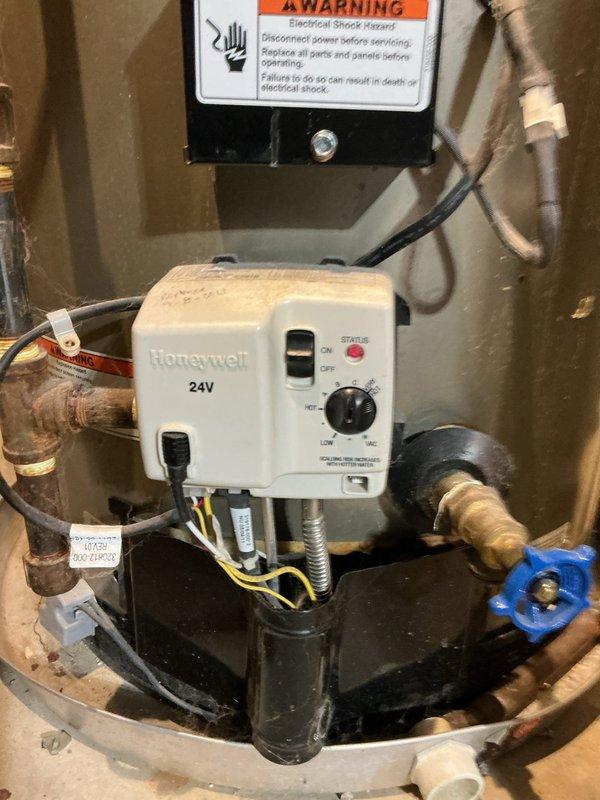 # HVAC Install - Call Back Summary

Returned to address chimney liner installation follow-up. Inspected metallic duct penetration through interior wall showing deterioration and paint damage around pipe entry point. Verified proper installation and sealing of aluminum/galvanized ductwork connections. Examined water heater mechanical assembly including Honeywell 24V control unit with proper electrical connections, copper piping with brass fittings, and blue-handled valve. Confirmed all control wiring, conduit, and safety labels in place and functioning correctly.