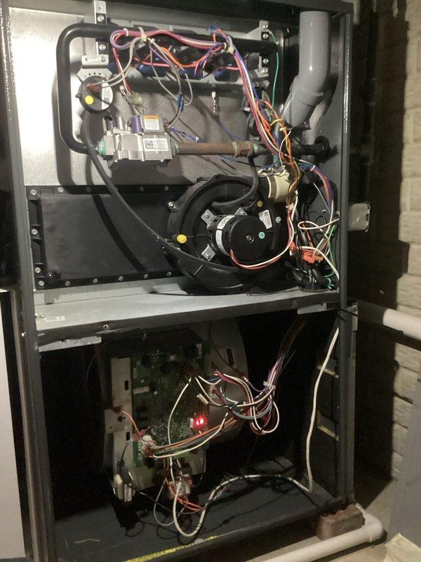 # HVAC Maintenance - AHM Service Report

Performed comprehensive annual heating maintenance on residential gas furnace air handler system. Conducted thorough inspection of all mechanical, electrical, and safety components with cabinet access panels removed for complete system evaluation.

Inspected blower motor assembly and verified proper operation of the cylindrical blower housing in lower compartment. Examined all electrical connections including control board wiring harnesses with red, blue, yellow, orange, brown, and pink wire bundles. Verified secure connections and proper routing throughout upper and lower compartments. Inspected green PCB control board for signs of wear, damage, or component failure—found to be in operational condition.

Evaluated gas valve assembly and associated ignition components including white ignition module mounted in upper section. Inspected black curved gas piping and metal mounting brackets for secure installation and proper seating. Examined gray PV