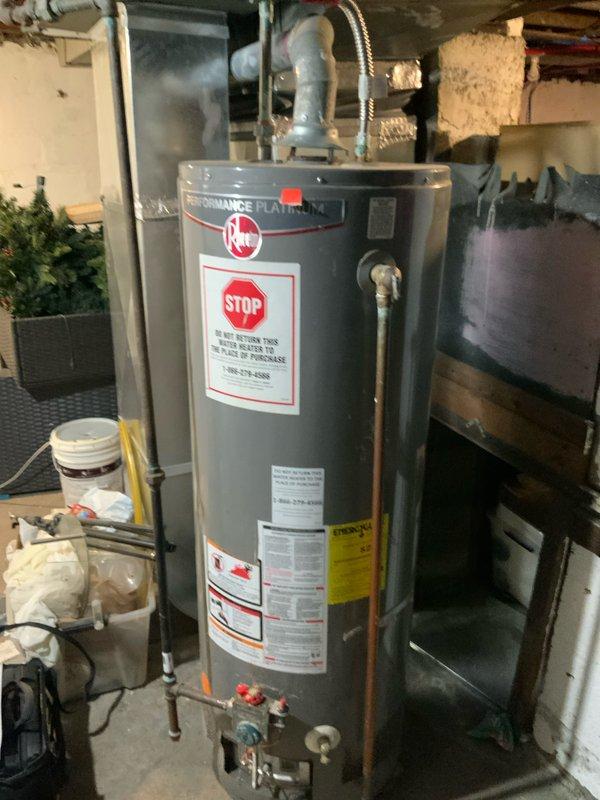 # Water Heater Replacement Estimate

Conducted on-site assessment for water heater replacement in residential basement utility area. Evaluated existing Rheem Performance Platinum water heater and surrounding plumbing infrastructure. During inspection, identified critical issues including absence of manufacturer tag on existing unit, inability to locate water drain connection, and missing main water shut-off valve. Documented electrical panel configuration and existing plumbing connections including copper supply lines with shut-off valves at base of unit. Photographed current installation showing top-mounted connections with flexible connectors and blue-painted piping. Provided comprehensive replacement estimate with service credit applied toward future installation work.