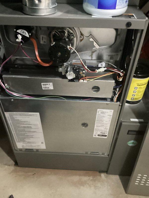 # HVAC Maintenance - AHM Service Report

Performed comprehensive air handler maintenance on residential HVAC system. Accessed furnace cabinet and inspected internal components including blower motor assembly, electrical connections, and wiring harnesses. All wire connections were verified secure with proper routing of orange, pink, red, and white conductor bundles throughout the unit.

Conducted thorough inspection of blower motor housing and associated mechanical components within the gray metal furnace cabinet. Examined capacitor, relay switches, and control components for proper operation. Verified all manufacturer specifications on unit labels and confirmed system integrity.

Replaced air filters and humidifier pads as scheduled for recurring maintenance service. Inspected ductwork connections at top of unit and confirmed secure attachment. All access panels were properly reinstalled following completion of maintenance procedures. System left in operational condition ready for cont